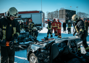 Sniegots koledžas praktisko mācību poligons. Tajā vairāki ugunsdzēsēji glābēji ap bojātām automašīnā. Fonā ugunsdzēsības automašīna.