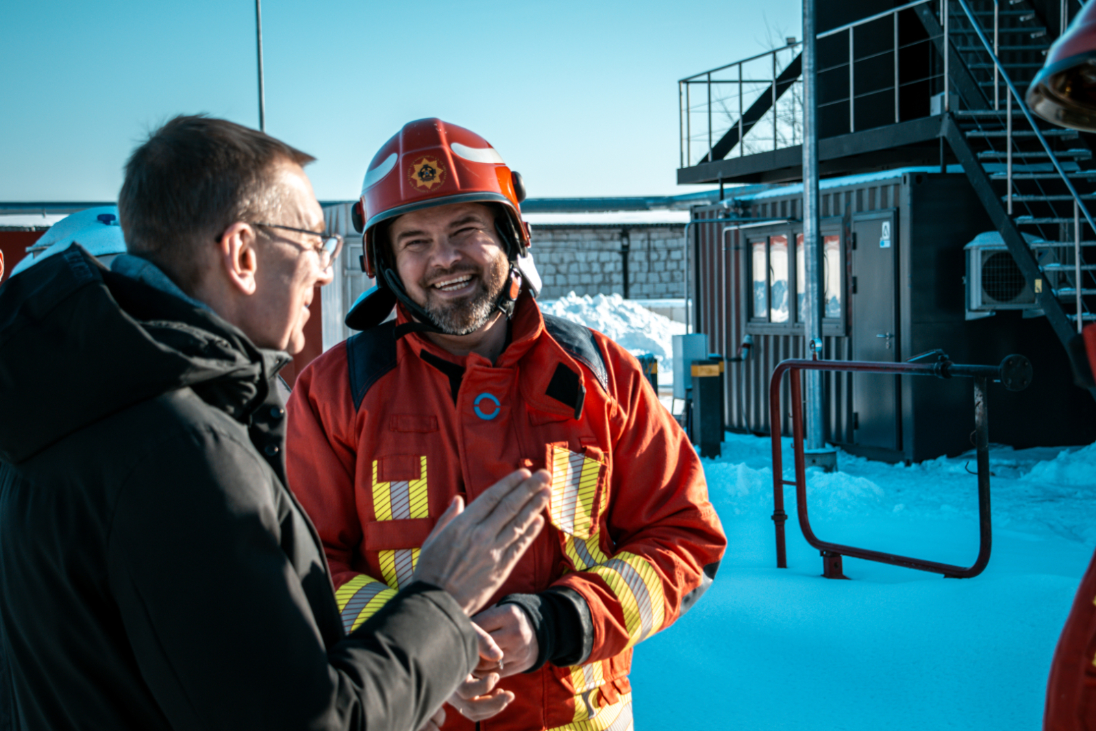 Valsts prezidents Edgars Rinkēvičs sarunājas ar Valsts ugunsdzēsības un glābšanas dienesta priekšnieku ģenerāli Mārtiņu Baltmani. Viņi atrodas sniegotā koledžas mācību poligonā.