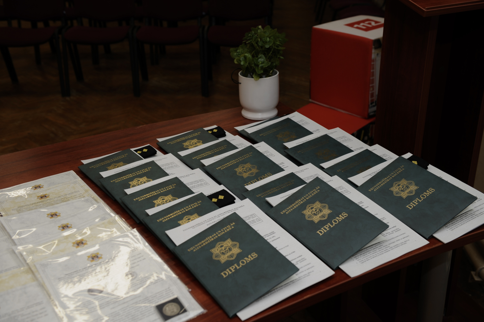 Uz galda izkārtoti diplomi